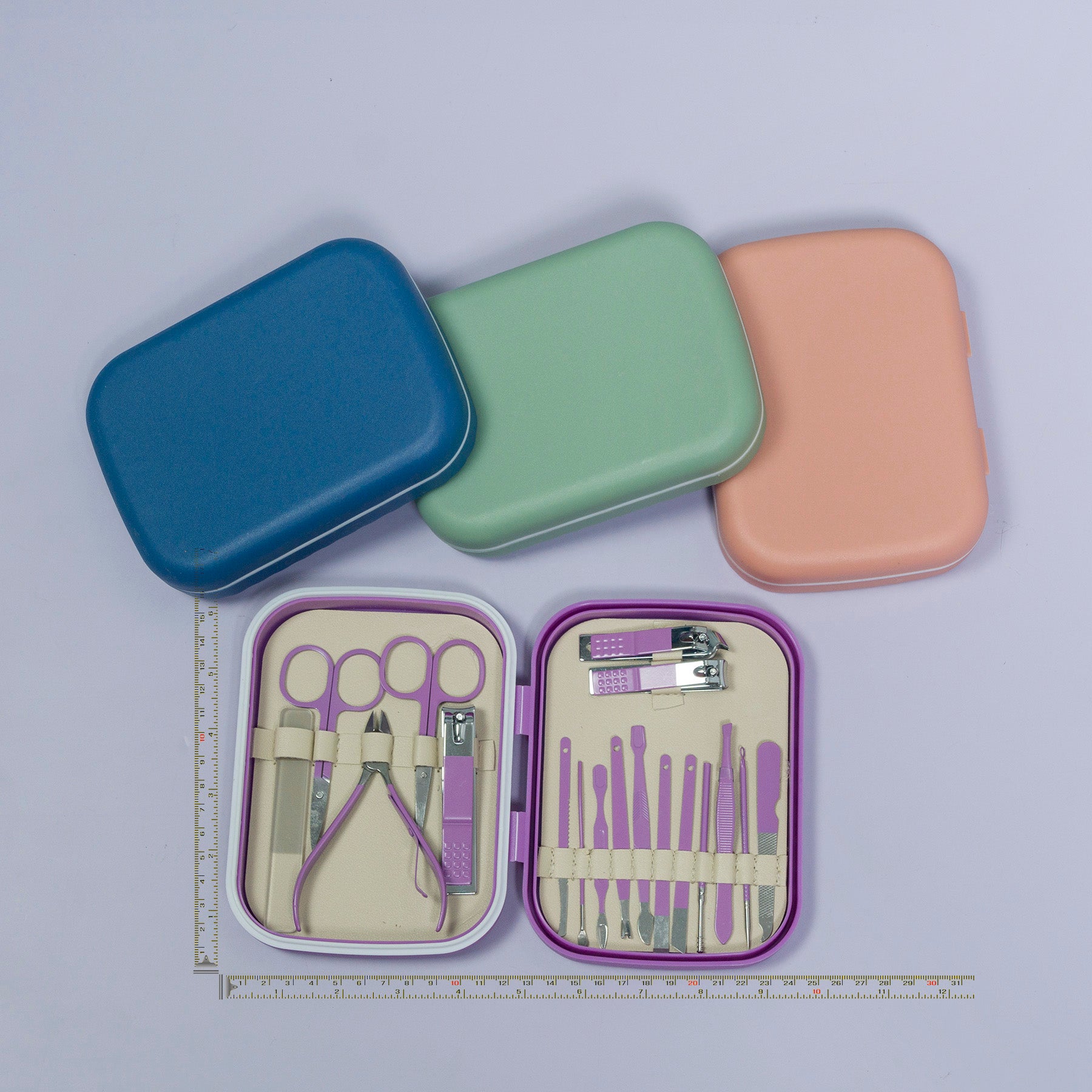 Manicure set with tools in an open case, surrounded by closed cases on a light purple background.