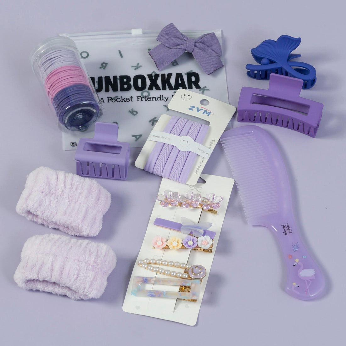 Collection of purple hair accessories including clips, bows, and a comb on a gray background.