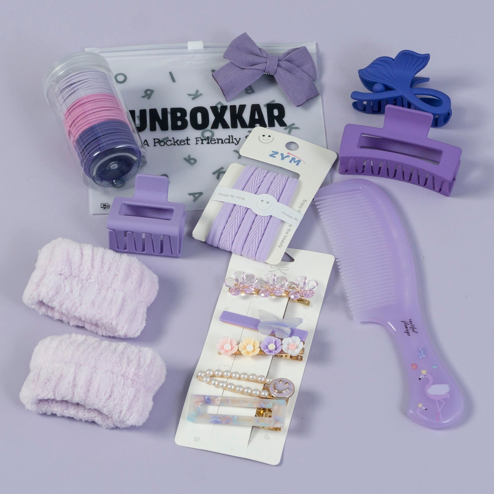 Collection of purple hair accessories including clips, bows, and a comb on a gray background.