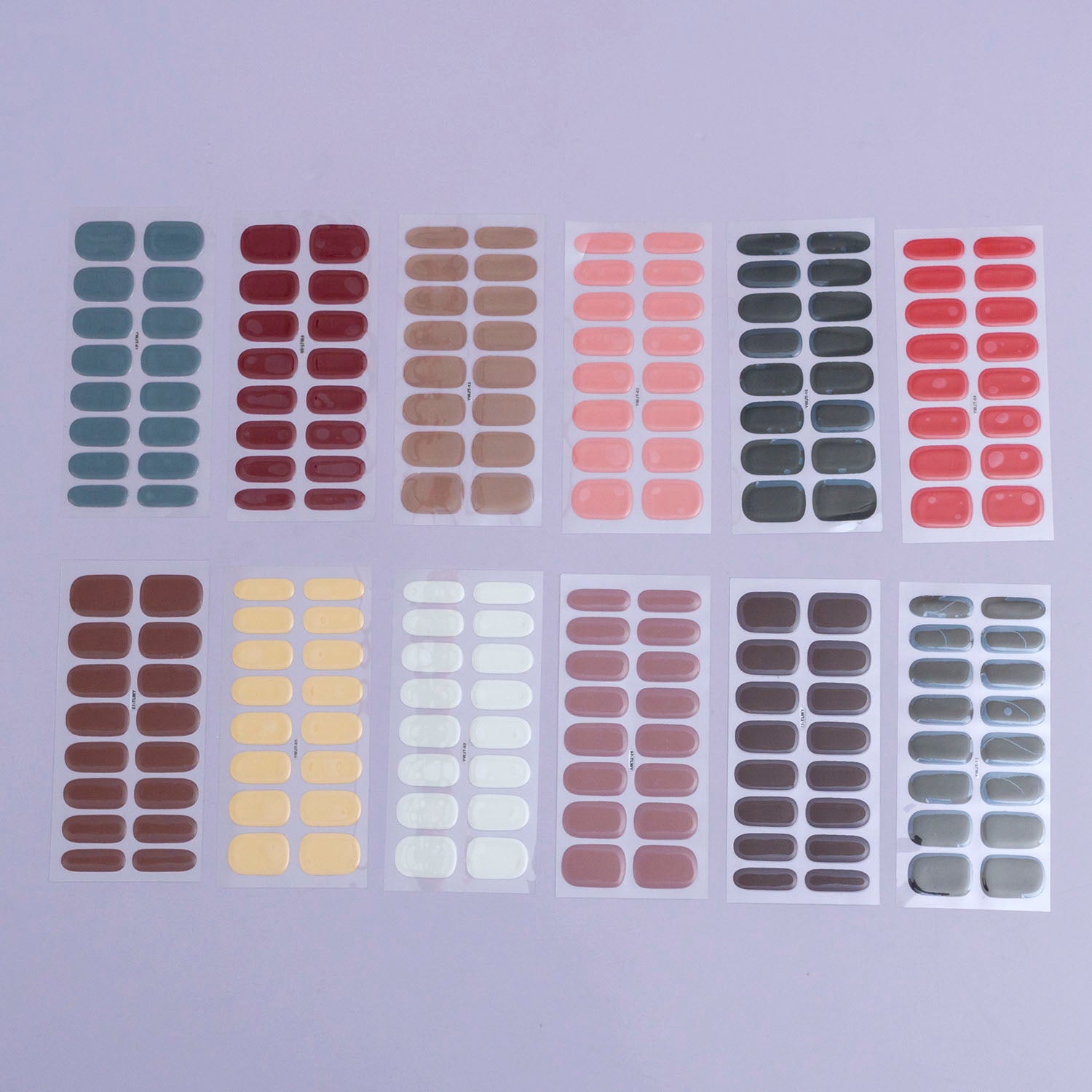 Assorted artificial gel nails in various colors displayed in rows, each row representing a different nail size.