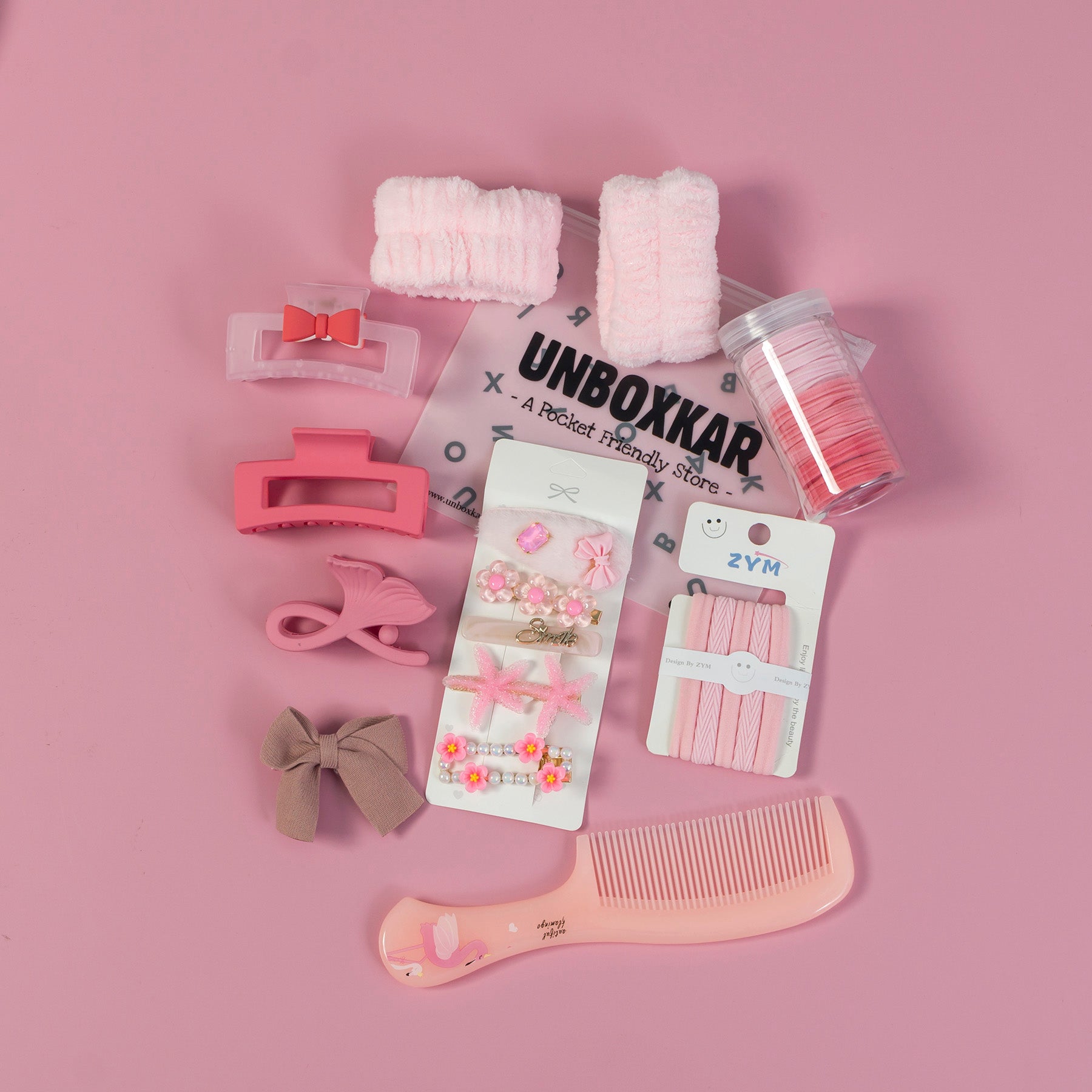 Collection of hair accessories and tools on a pink background with 'Unboxkar' branding.