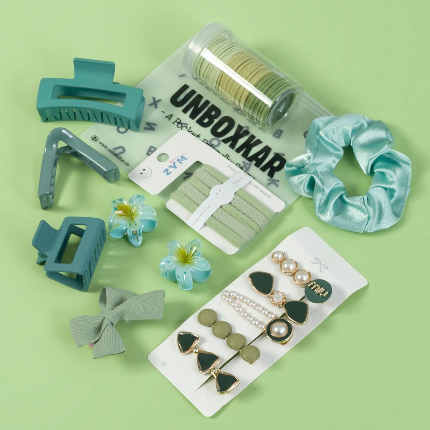 Collection of hair accessories including clips, flowers, and earrings on a green background with 'Unboxxar' branding.